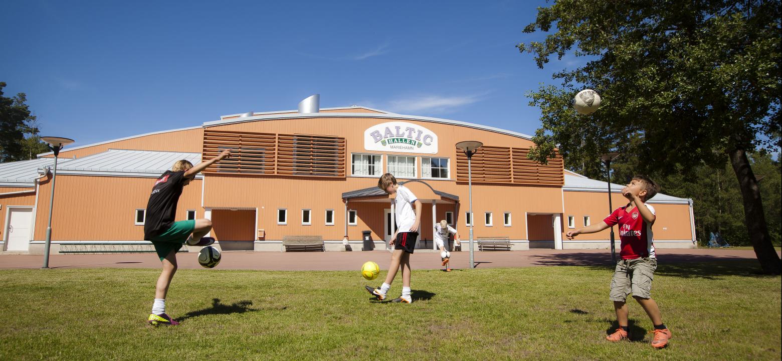 Bilden visar barn som passar fotboll utanför Baltichhallen