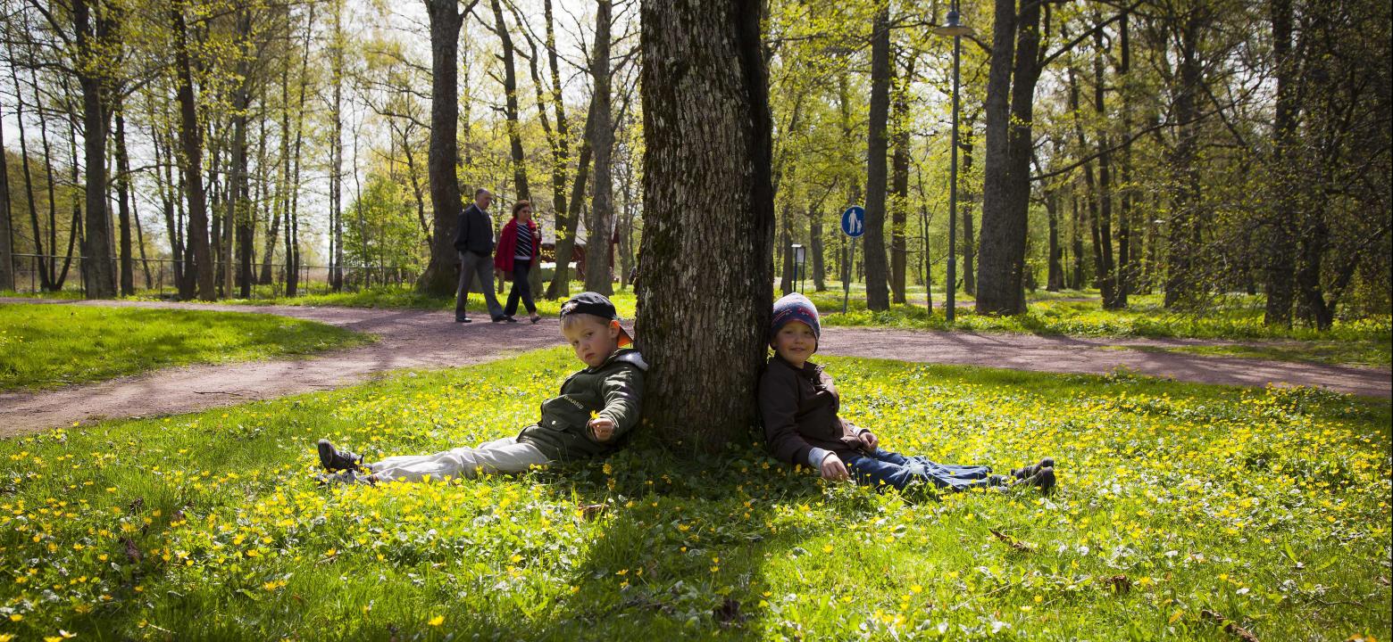 Två barn lutar mot ett träd