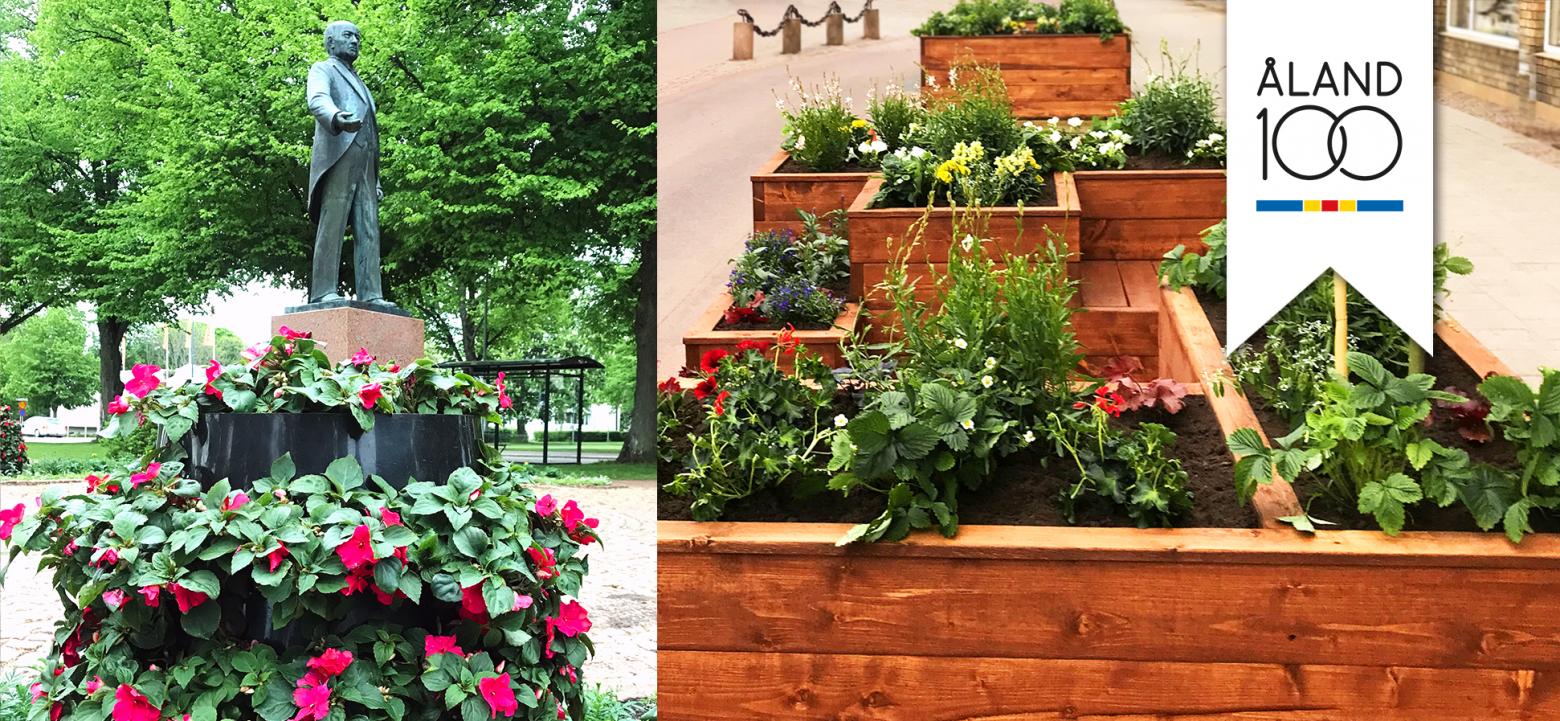 Blommor i hög formation framför en staty samt möbel med blommor i