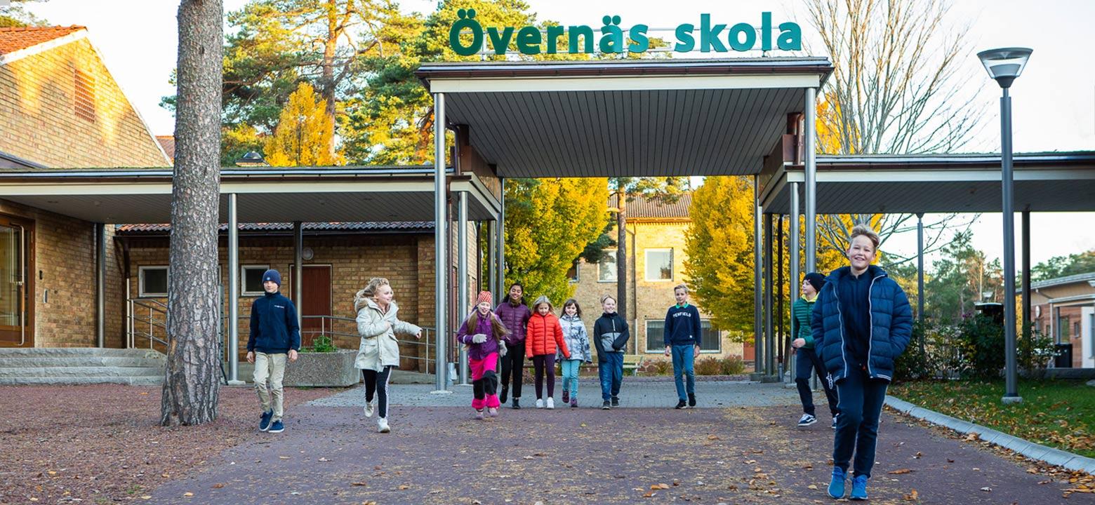 Bilden visar elever framför huvudingången och utetaket till Övernäs skola