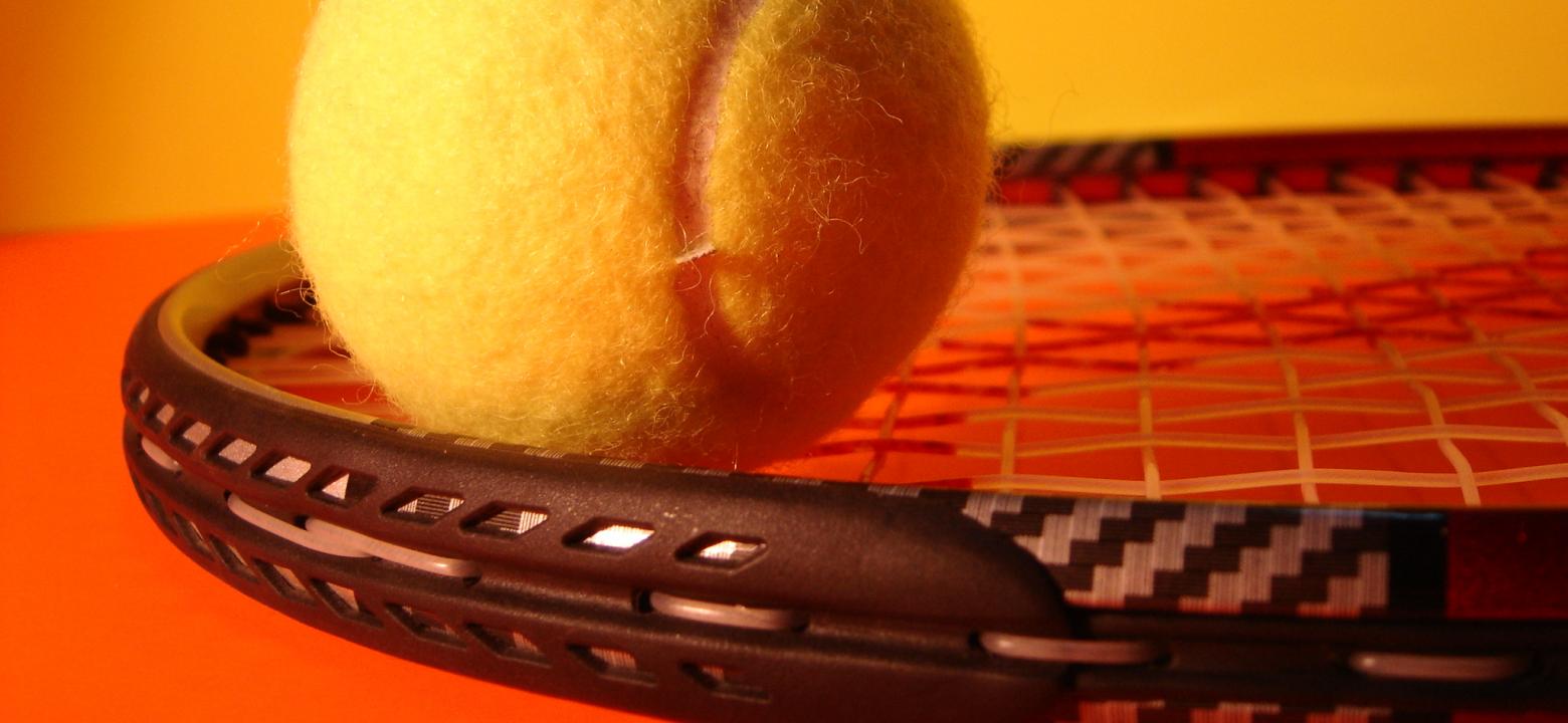 Bilden visar en racket med tennisboll på