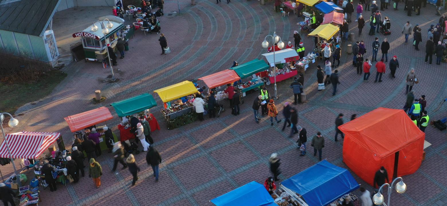 Torget med färgglada torgbord och besökare