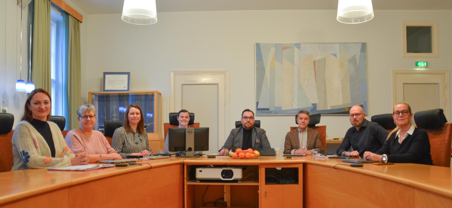 Kristine, Nina, Julia, Emma (kanslichef), Michele, Arne (stadsdirektör), Peter och Monica. På bilden saknas Bert. Foto på stadsstyrelsen under sammanträde i stadsstyrelserummet