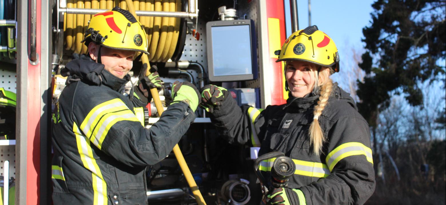 Bilden visar en manlig och en kvinnlig brandman 