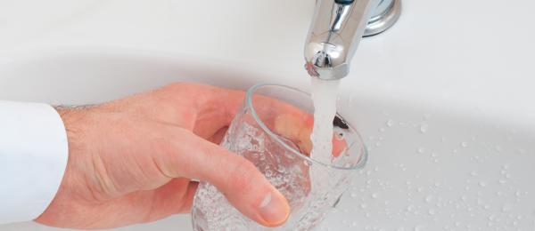 Bilden visar en hand som tappar vatten från en kran