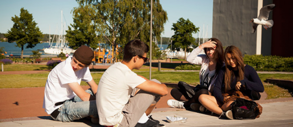 Bilden visar ungdomar som sitter i en park